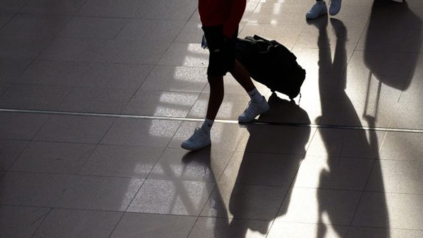 Passagiere gehen mit ihren Koffern durch ein Flughafenterminal
