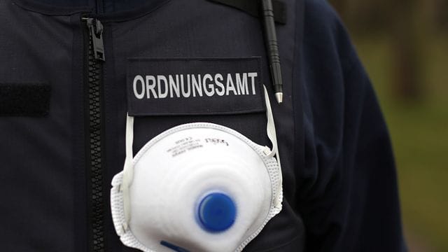 Ein Mitarbeiter des Ordnungsamts trägt einen Mundschutz an seiner Weste (Symbolbild): Zehnttausende Buß- und Verwarngelder wurden in Sachsen seit Ausbruch der Corona-Pandemie verhängt. Ein Mitarbeiter des Ordnungsamts trägt einen Mundschutz an seiner Weste (Symbolbild): Zehnttausende Buß- und Verwarngelder wurden in Sachsen seit Ausbruch der Corona-Pandemie verhängt.