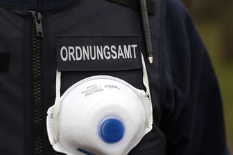 Ein Mitarbeiter des Ordnungsamts trägt einen Mundschutz an seiner Weste (Symbolbild): Zehnttausende Buß- und Verwarngelder wurden in Sachsen seit Ausbruch der Corona-Pandemie verhängt.