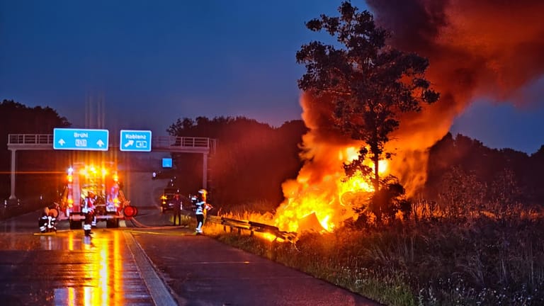 Rechts neben der A1 steigen am Sonntagabend Flammen und Rauch in den Himmel: Der Unfallwagen hatte nach seinem Überschlag Feuer gefangen.