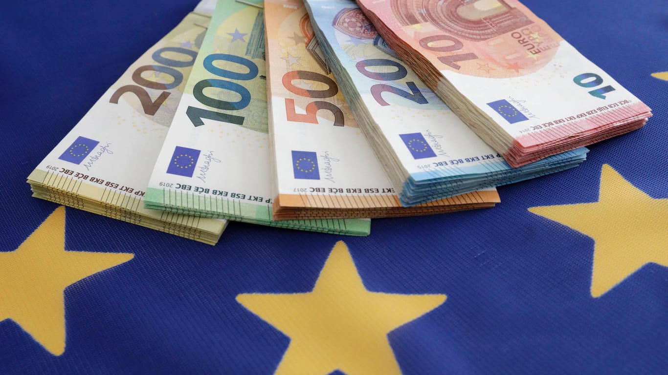 Euroscheine auf der EU-Flagge: Die Kommission hat Hilfsgelder wegen der Corona-Pandemie an die Mitglieder gezahlt.