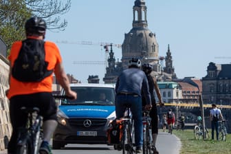 Ein Polizeiauto fährt auf dem Elberadweg in Dresden Patrouille: Das RKI meldet 404 neue Coronavirus-Fälle in Deutschland.