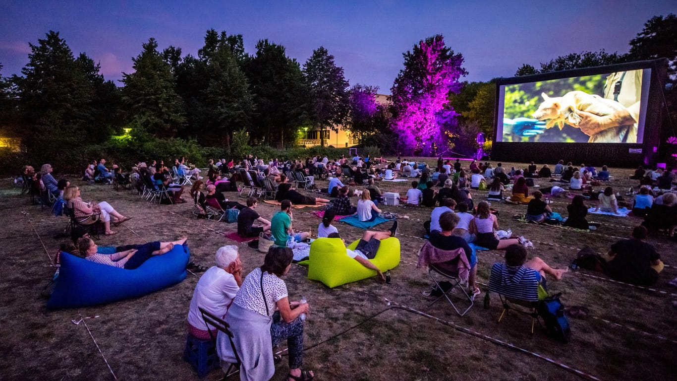 Menschen schauen einen Film in einem Freiluftkino (Symbolbild): Vom 14. Juli bis 22. August gibt es in Leipzig Open-Air-Kino.