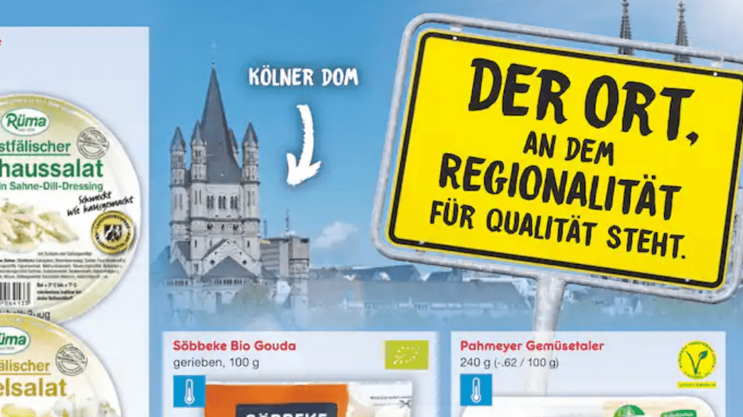 Die Spitzen des Kölner Doms ragen hinter dem Ortsschild hervor – aber der Pfeil zeigt an eine völlig falsche Stelle.