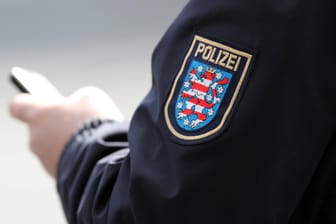 Das Wappen der Thüringer Polizei ist auf einer Jacke zu sehen (Symbolbild): Beamte haben eine Wohnung in Erfurt durchsucht.