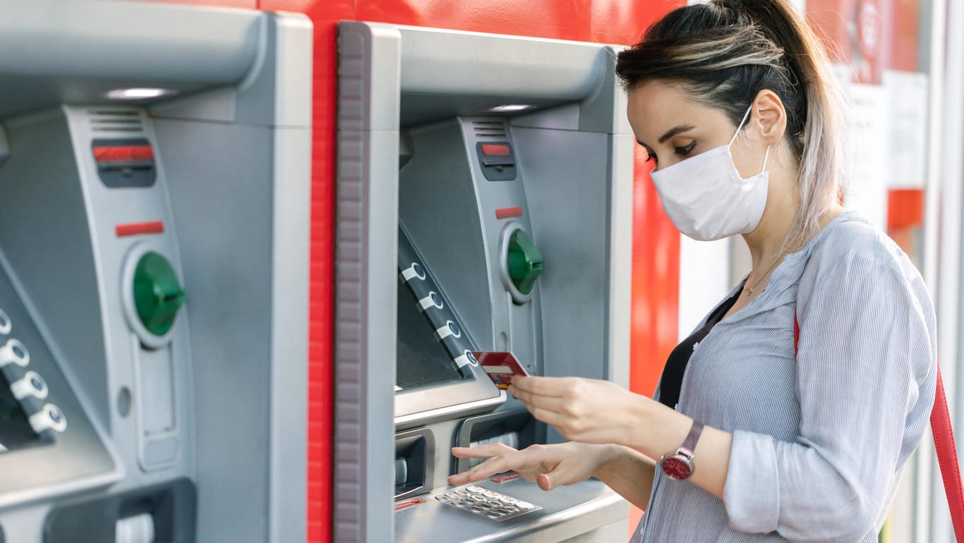 Frau am Bankautomaten (Symbolbild): Was ist, wenn die Bank bei der Überweisung an den Vermieter einen Fehler macht?