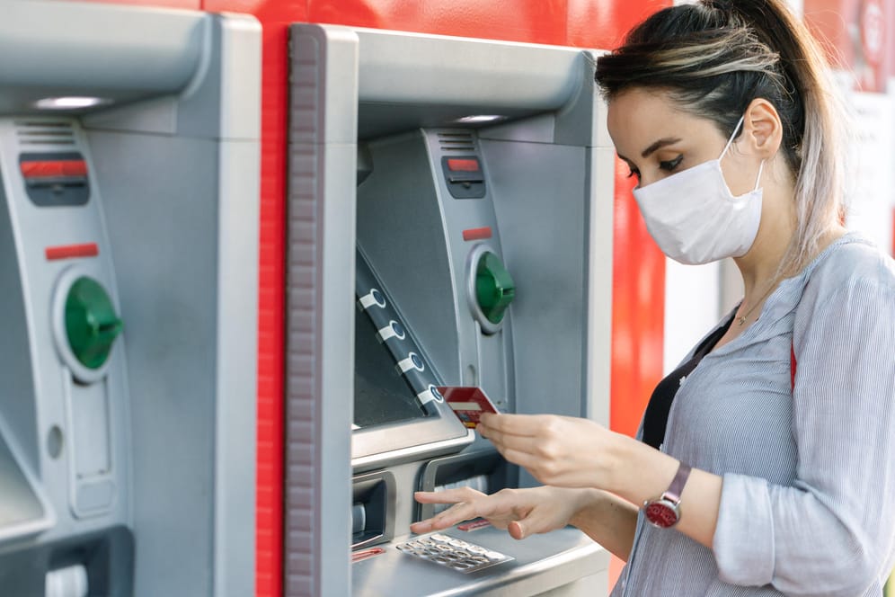 Frau am Bankautomaten (Symbolbild): Was ist, wenn die Bank bei der Überweisung an den Vermieter einen Fehler macht?