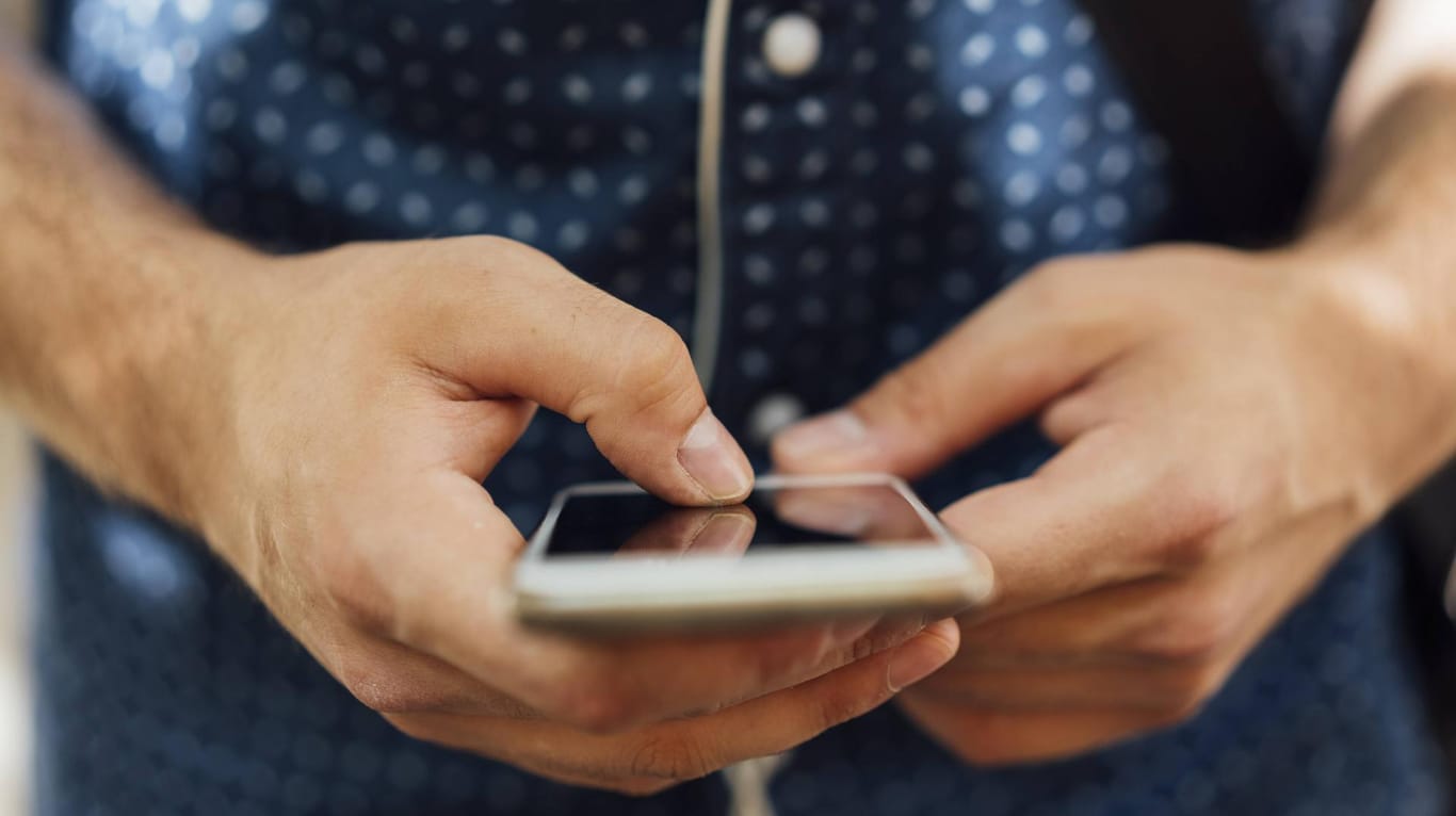 Ein Mann mit Smartphone (Symbolbild): Verbraucherschützer warnen vor gefährlichen SMS.