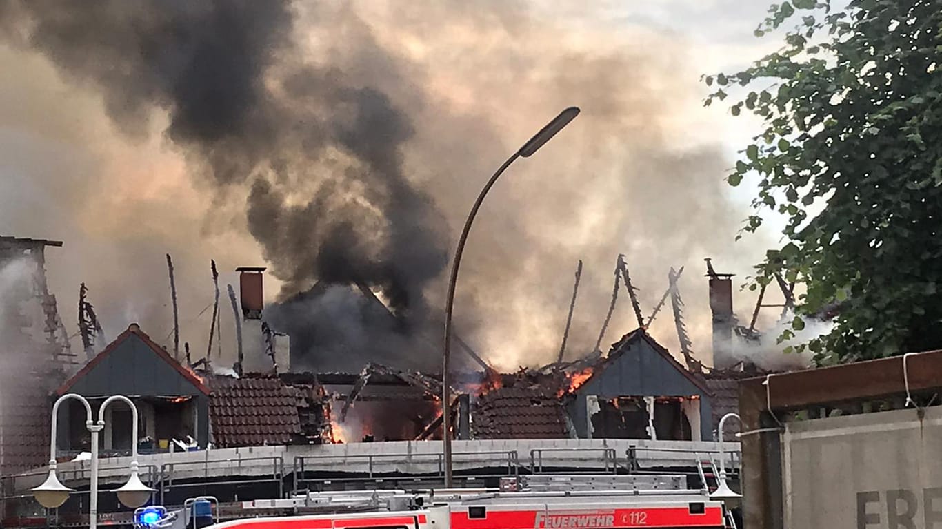 Ein Feuerwehrfahrzeug steht vor einem brennenden Haus: Über Twitter und Apps wurde die Bevölkerung gewarnt.