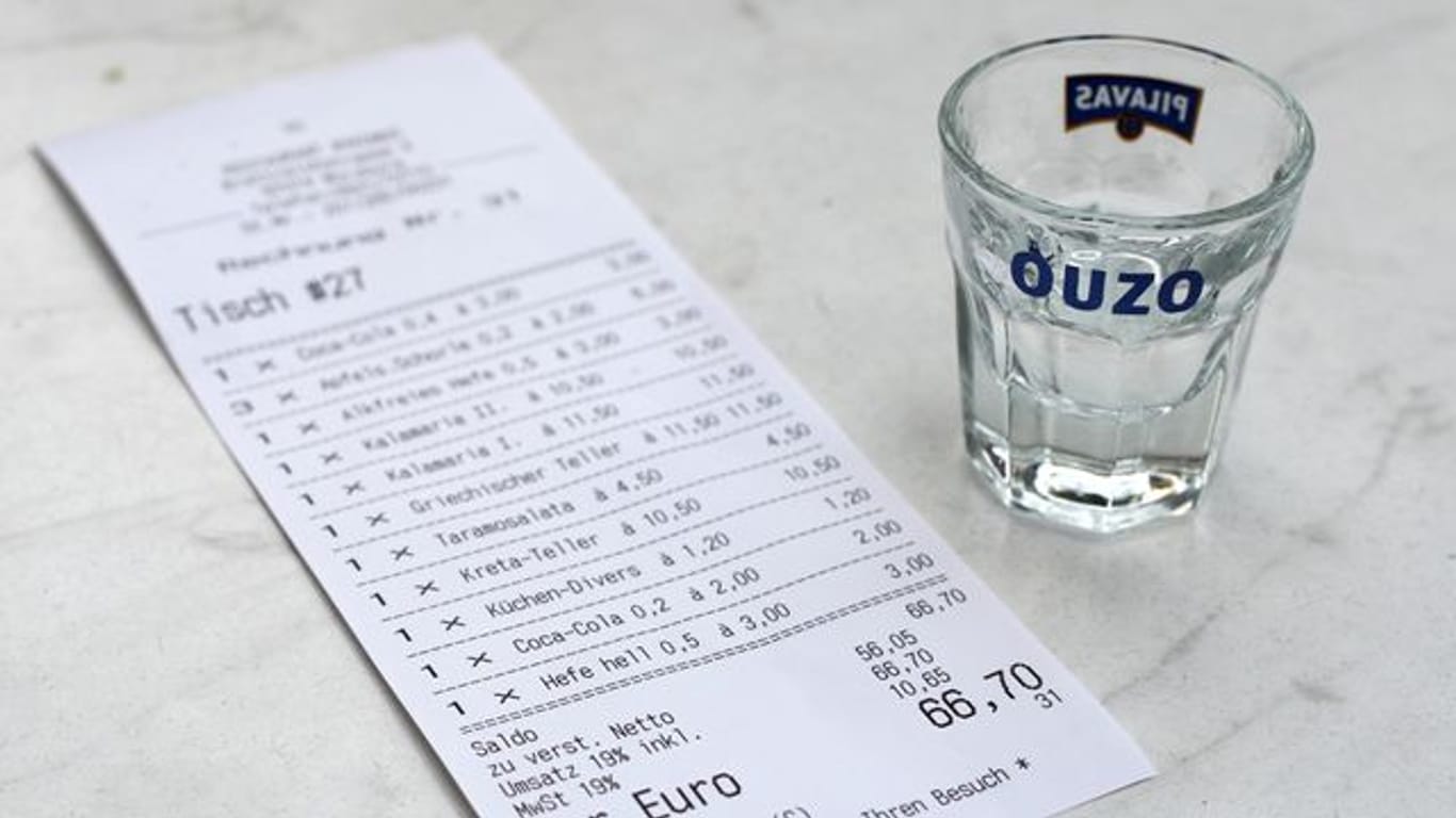 Eine Rechnung und ein leeres Ouzo-Glas: Eine Studie aus Hamburg zeigt, unter welchen Umständen Kellner ein höheres Trinkgeld erhalten.