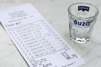 Eine Rechnung und ein leeres Ouzo-Glas: Eine Studie aus Hamburg zeigt, unter welchen Umständen Kellner ein höheres Trinkgeld erhalten.