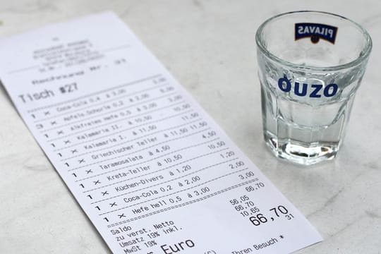 Eine Rechnung und ein leeres Ouzo-Glas: Eine Studie aus Hamburg zeigt, unter welchen Umständen Kellner ein höheres Trinkgeld erhalten.