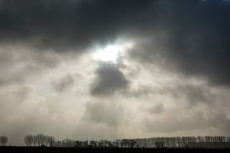 Die Sonne kommt hinter einer dunklen Wolkendecke hervor