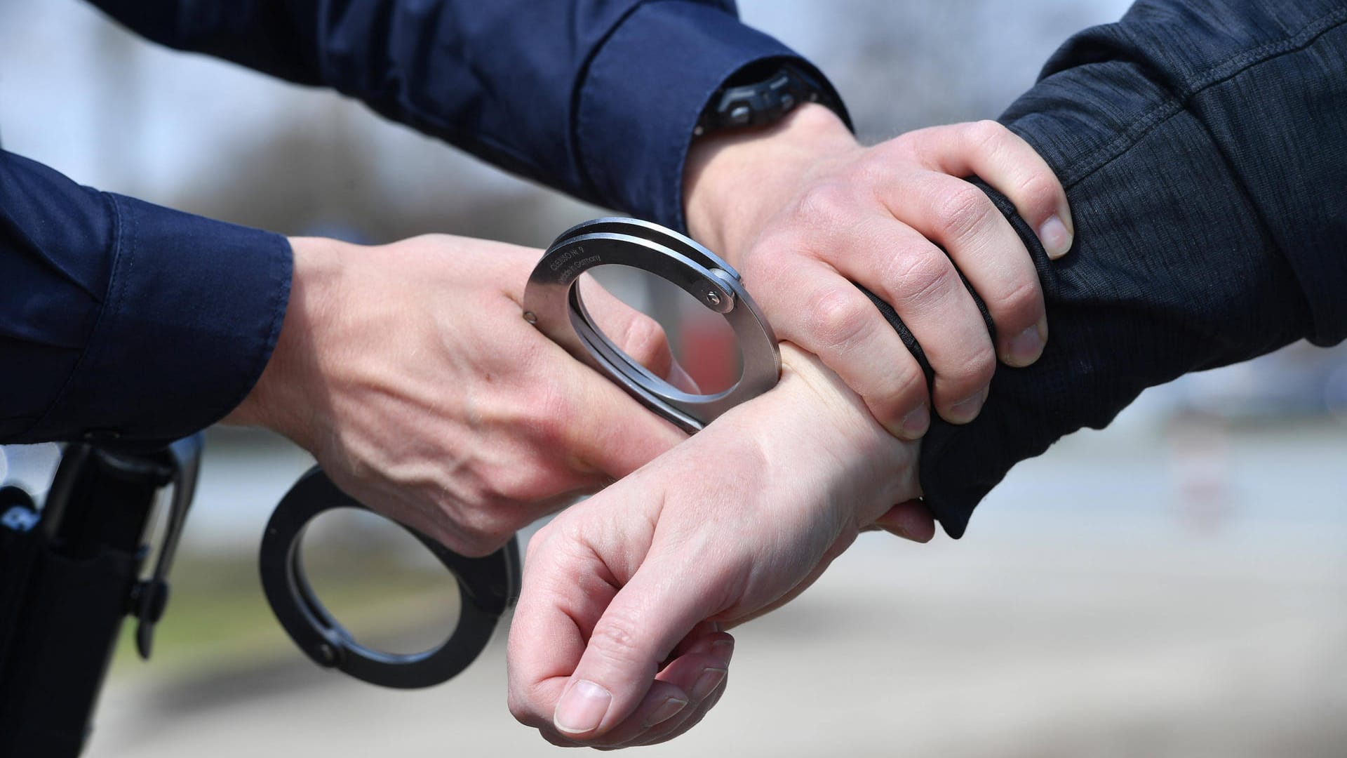 Ein Polizeibeamter legt einer Person Handschellen an (Symbolbild): Der Mann hat eine Notlage vorgegaukelt. Ein Polizeibeamter legt einer Person Handschellen an (Symbolbild): Der Mann hat eine Notlage vorgegaukelt.