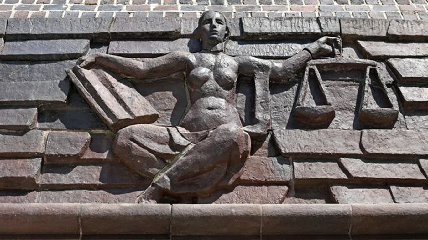 Blick auf die Justitia über dem Eingang eines Gerichts