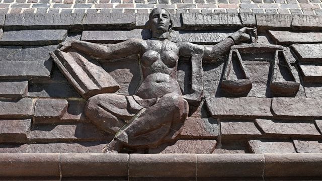 Blick auf die Justitia über dem Eingang eines Gerichts