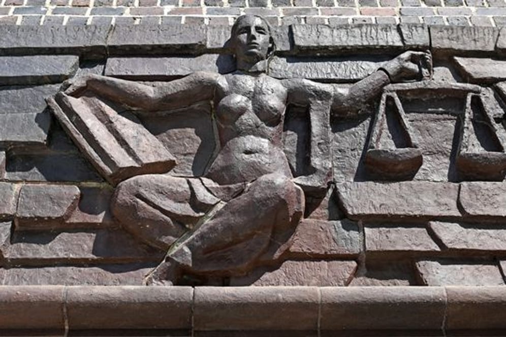Blick auf die Justitia über dem Eingang eines Gerichts