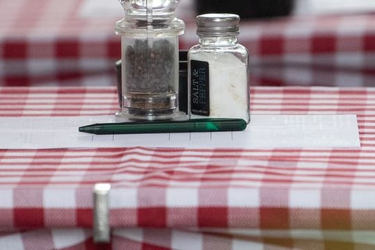 Salz, Pfeffer und ein Aschenbecher stehen auf einem Tisch