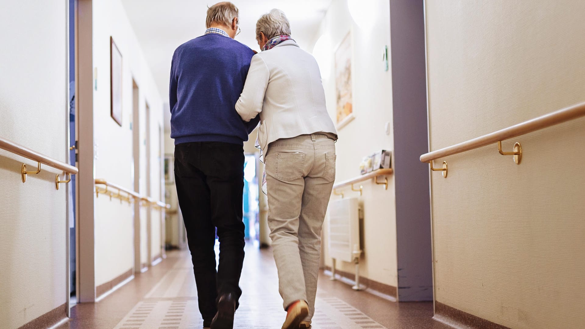 Ein Paar geht durch einen Flur: Wer grauen Star ambulant operieren lässt, kann sich in der Regel noch am selben Tag aus der Praxis oder Klinik abholen lassen.