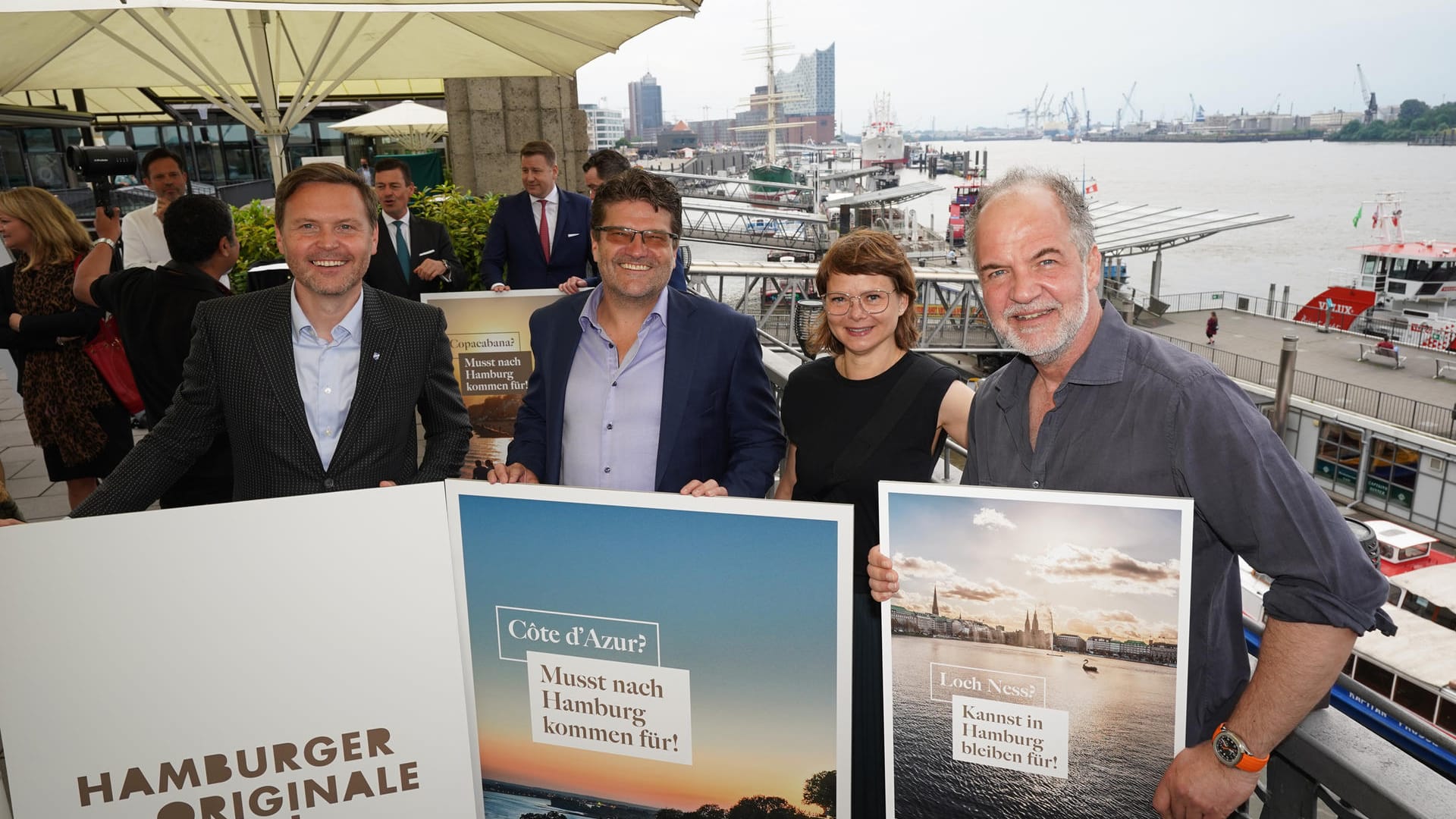 Schauspieler Marek Erhardt (r-l), Julia Bode, Inhaberin Restaurant Witwenball, Marc Ciunis, Gastronom und Hotelier (Hotel Tortue), und Hubert Neubacher, Geschäftsführer Barkassen-Meyer, halten Plakate mit der Aufschrift "Kannst in Hamburg bleiben für" und "Musst nach Hamburg kommen für" hoch. Schauspieler Marek Erhardt (r-l), Julia Bode, Inhaberin Restaurant Witwenball, Marc Ciunis, Gastronom und Hotelier (Hotel Tortue), und Hubert Neubacher, Geschäftsführer Barkassen-Meyer, halten Plakate mit der Aufschrift "Kannst in Hamburg bleiben für" und "Musst nach Hamburg kommen für" hoch.