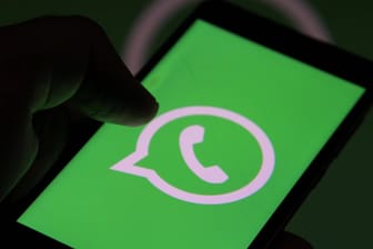 Das WhatsApp-Logo auf einem Smartphone (Symbolbild): Kriminelle nutzen auch den Messenger für ihre Betrugsversuchen.