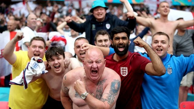 Englische Fußballfans feiern den Sieg gegen Deutschland - Schulter an Schulter - im Wembley Stadion.