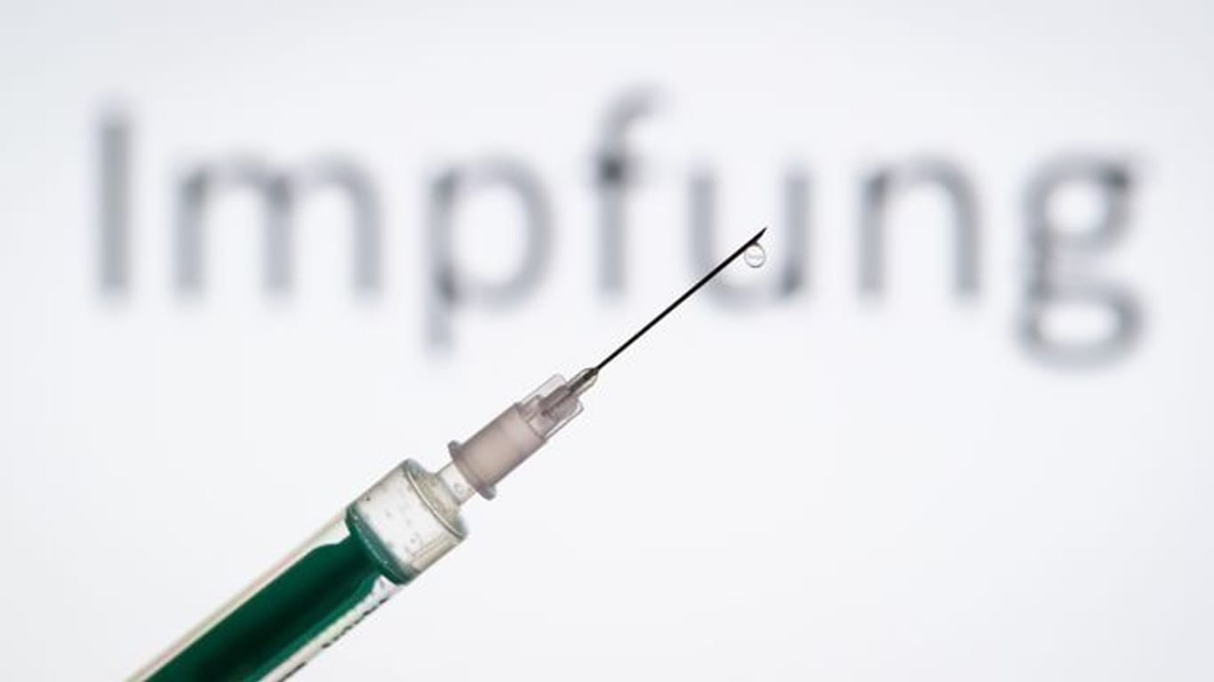 Eine Spritze wird vor den Schriftzug "Impfung" gehalten (Symbolbild): Mehr als 50 Prozent der Bürger sind bereits einmal geimpft.