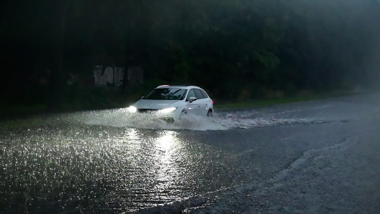 Ein Auto fährt durch Wasser (Symbolbild): In vielen Teilen Deutschlands hat es bereits Überschwemmungen gegeben.