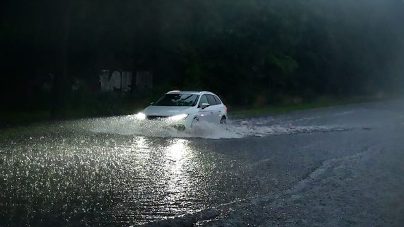 Ein Auto fährt durch die überflutete Gladbacher Straße