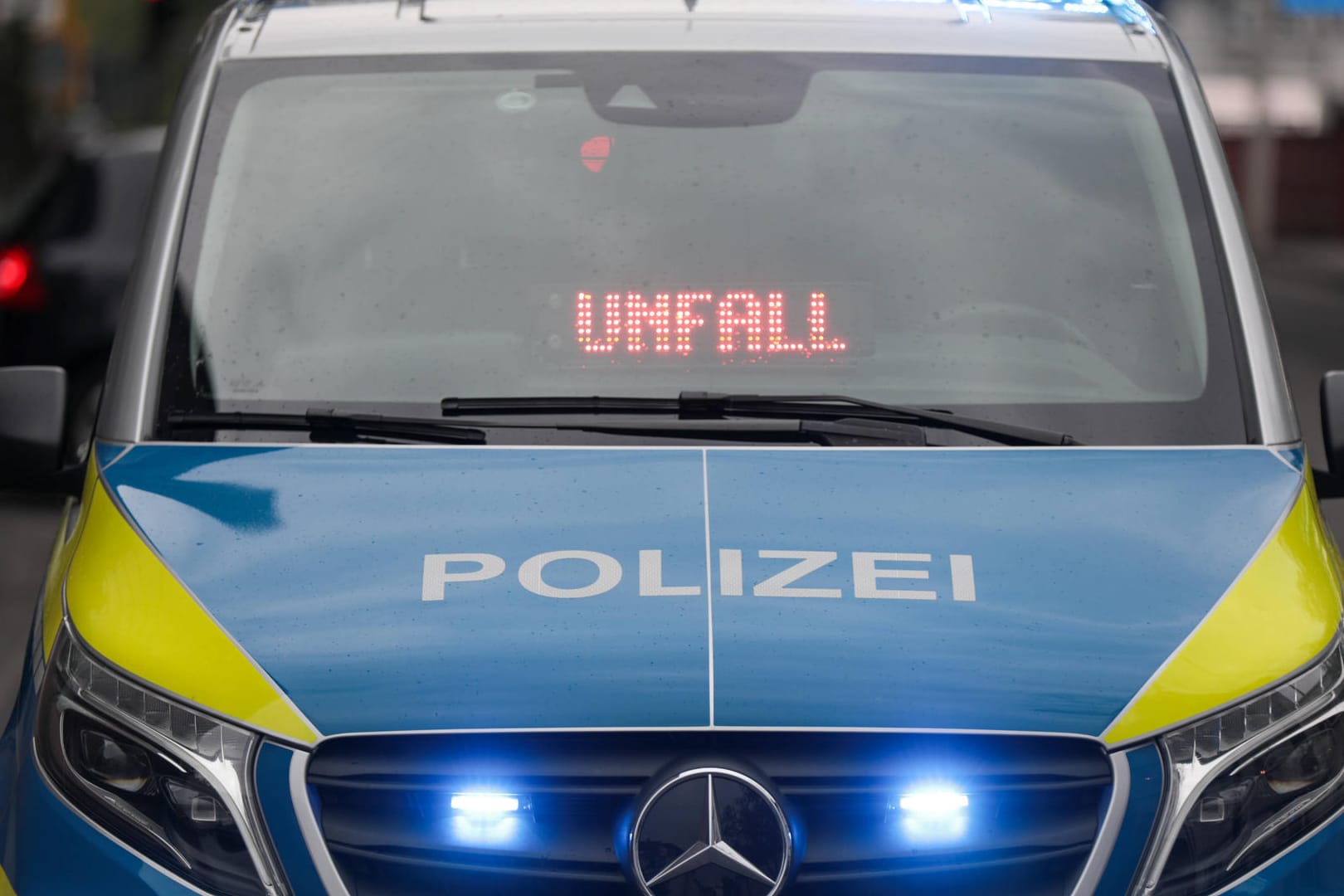Auf einem Streifenwagen mit Blaulicht leuchtet die Anzeige "UNFALL". Der Mann konnte unbeschadet aus seinem Wagen aussteigen.
