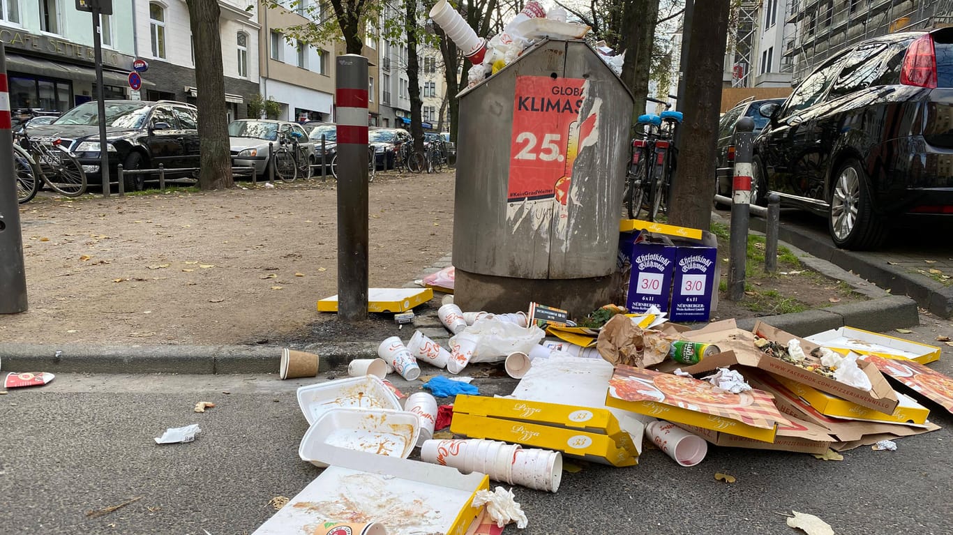 Leere Becher und Kartons stapeln sich neben einem Mülleimer in der Kölner Südstadt (Archivbild): Der Verbrauch an Einwegverpackungen hat in Corona-Zeiten zugenommen.
