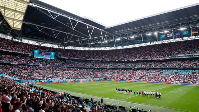 Die Spieler von Deutschland und England stehen bei den Nationalhymnen vor dem Spiel auf dem Rasen. Die Spieler von Deutschland und England stehen bei den Nationalhymnen vor dem Spiel auf dem Rasen.