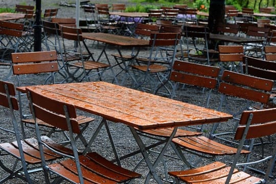 Verwaiste Tische im Biergarten: Das nasskalte Wetter hält auch weiter an