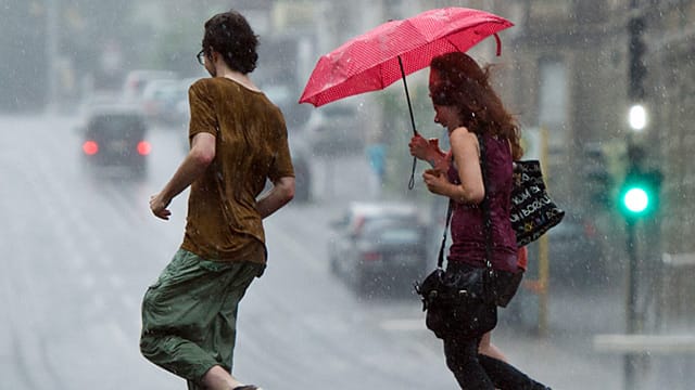 Junge Leute bringen sich in Stuttgart vor einem Platzregen in Sicherheit. Am Mittwoch regnet es langanhaltend. Junge Leute bringen sich in Stuttgart vor einem Platzregen in Sicherheit. Am Mittwoch regnet es langanhaltend.