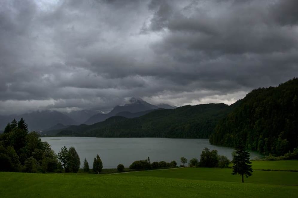 Die Alpen zeigen sich am Weißensee bei Füssen in Bayern wolkenverhangen