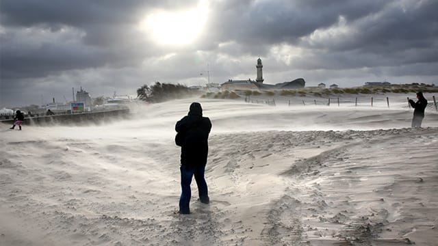 Sturm wirbelt den Sand in Rostock-Warnemünde auf.