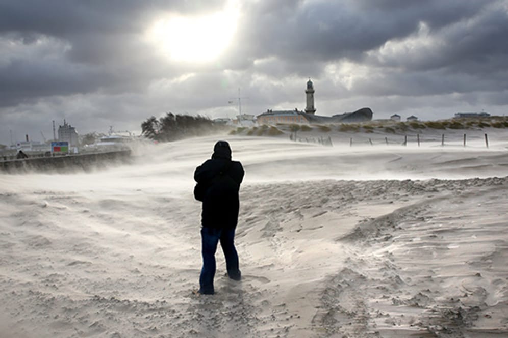 Sturm wirbelt den Sand in Rostock-Warnemünde auf.