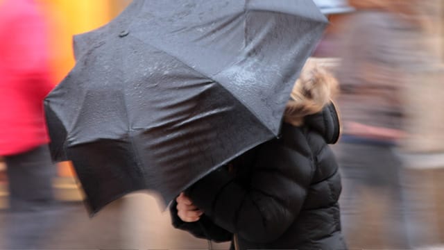 Spaziergängerin kämpft mit Windböen (Symbolfoto): Der Dienstag wird im Norden ungemütlich.