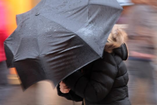 Spaziergängerin kämpft mit Windböen (Symbolfoto): Der Dienstag wird im Norden ungemütlich.