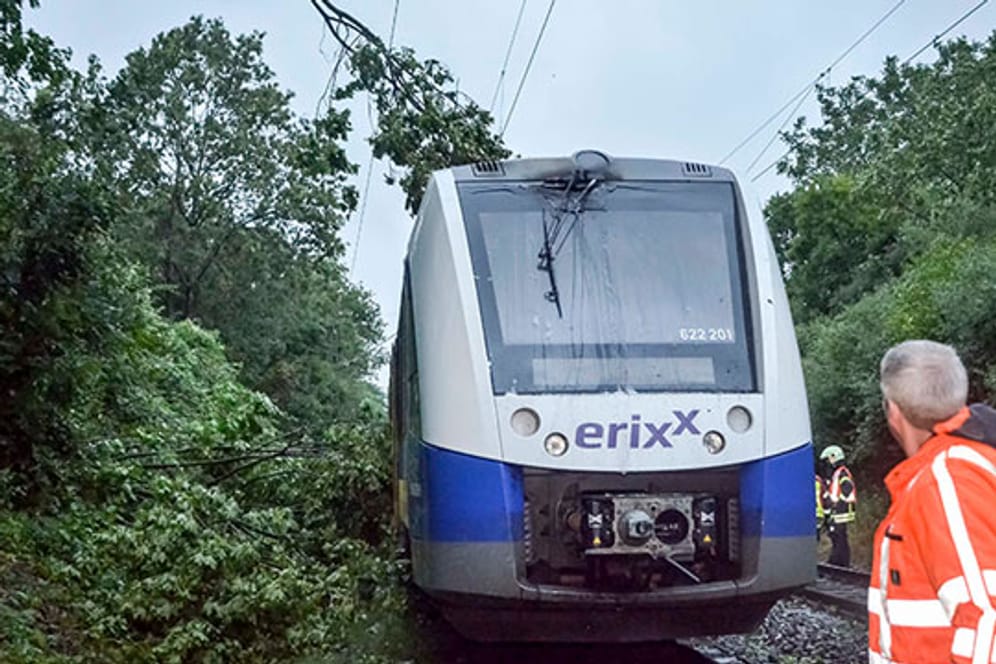 Einsatzkräfte begutachten den Zug, der in Brand geraten war.