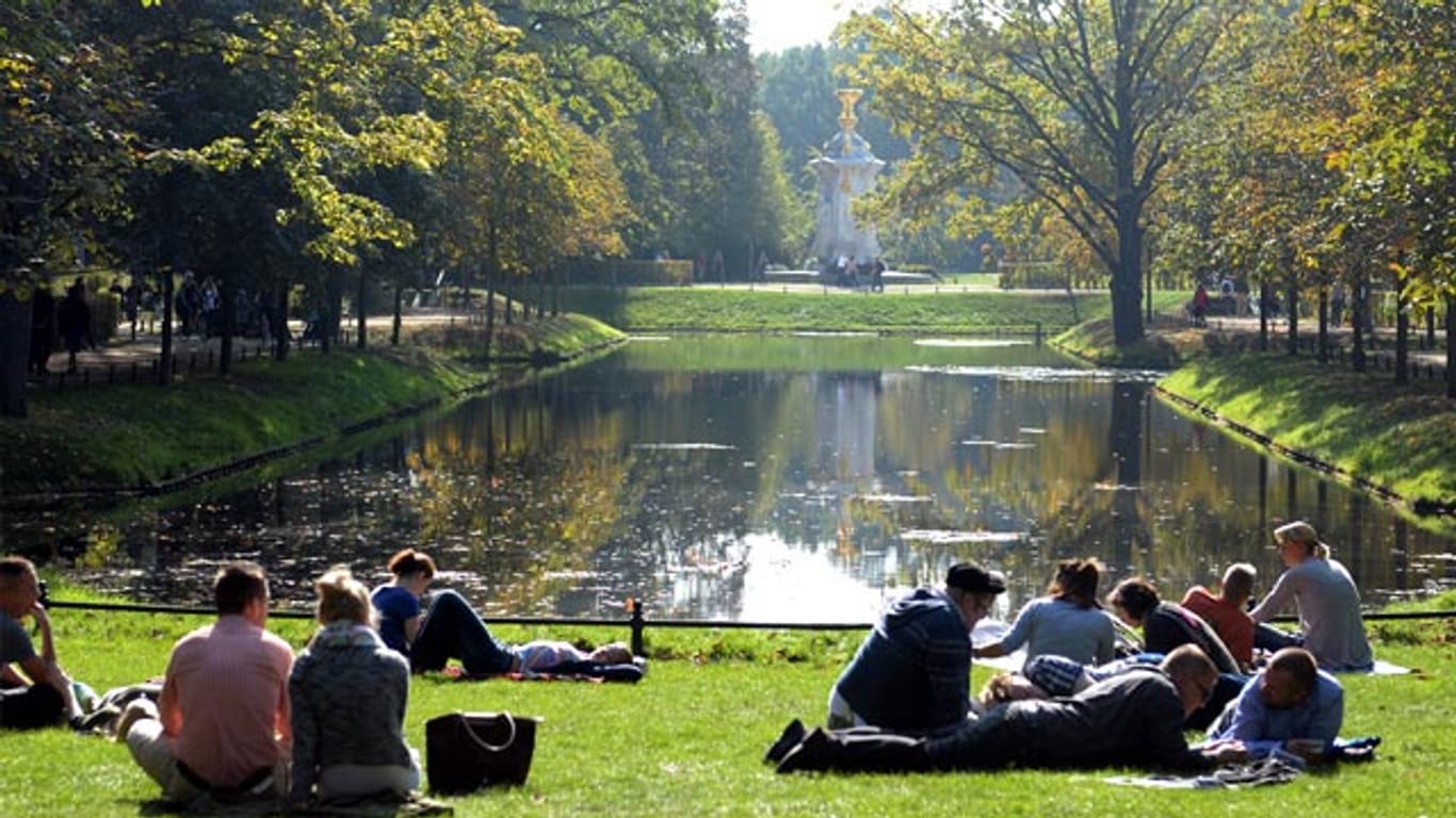 Spaziergänger ruhen sich in der Herbstsonne im Tiergarten in Berlin aus.