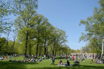 Menschen genießen die Sonne im Volkspark Friedrichshain in Berlin.