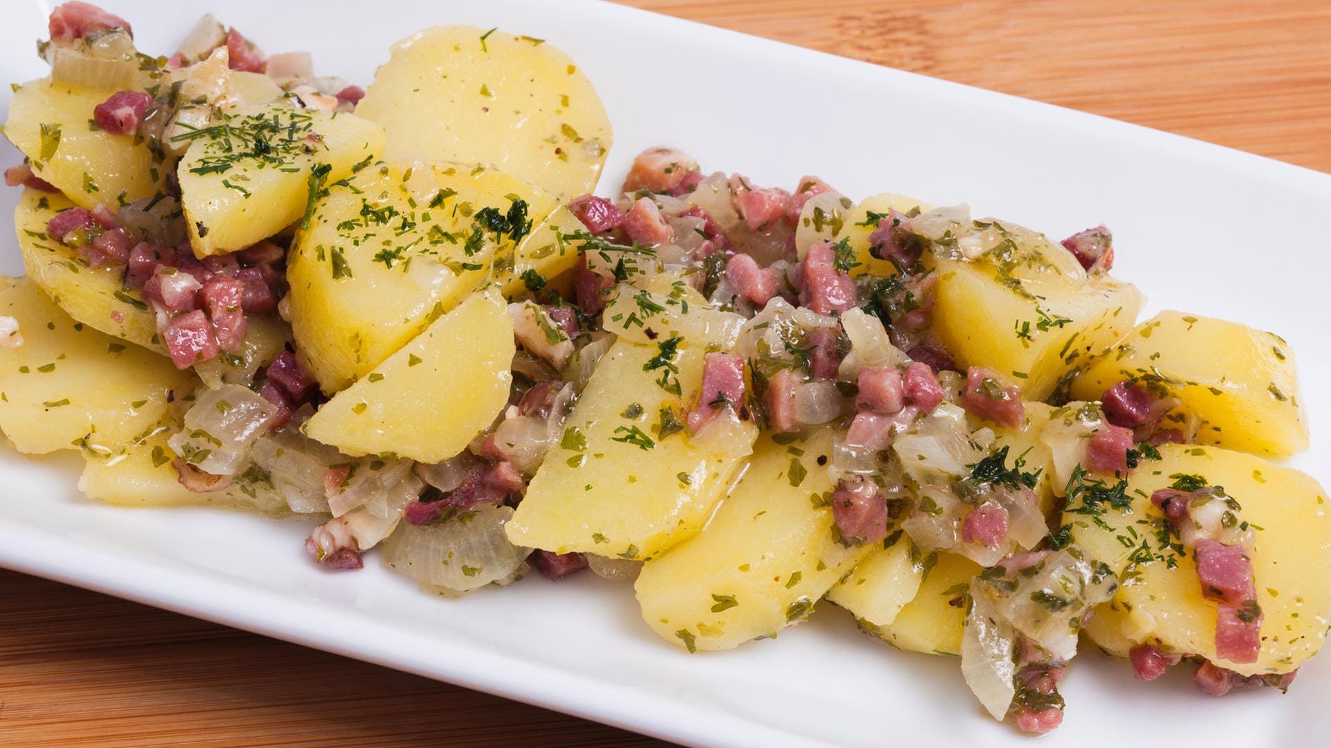 Kartoffelsalat mit Essig und Öl: Diese Variante kommt ganz ohne Mayonnaise aus und wird warm serviert.