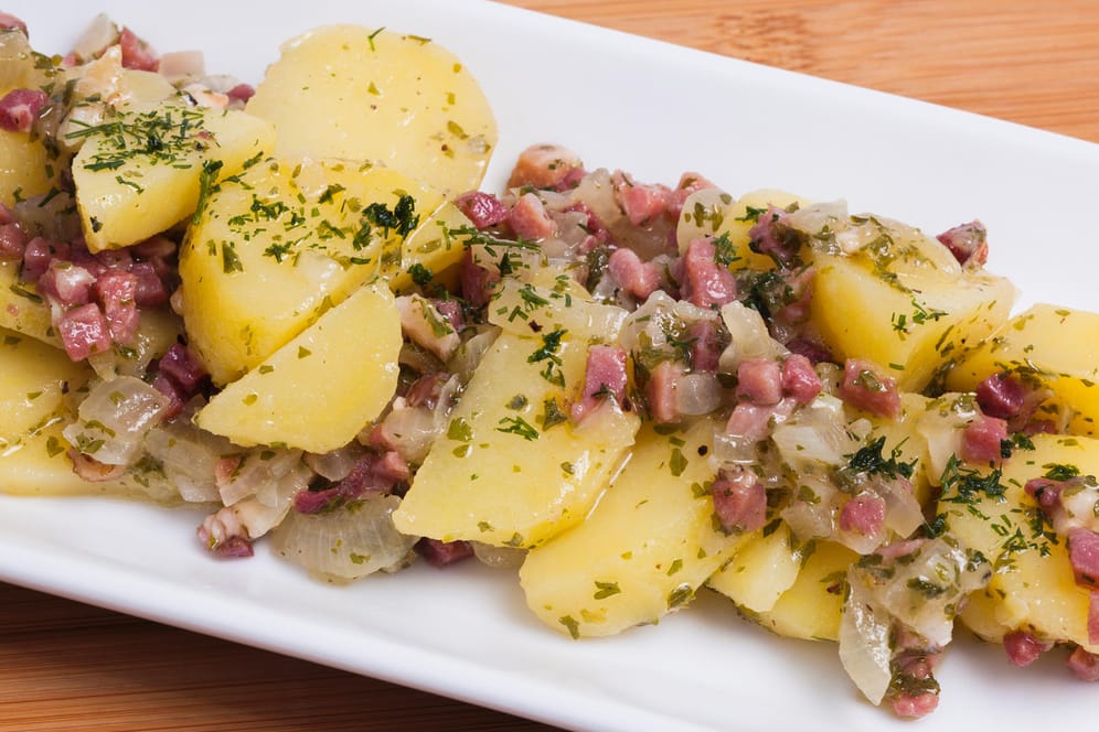 Kartoffelsalat mit Essig und Öl: Diese Variante kommt ganz ohne Mayonnaise aus und wird warm serviert.