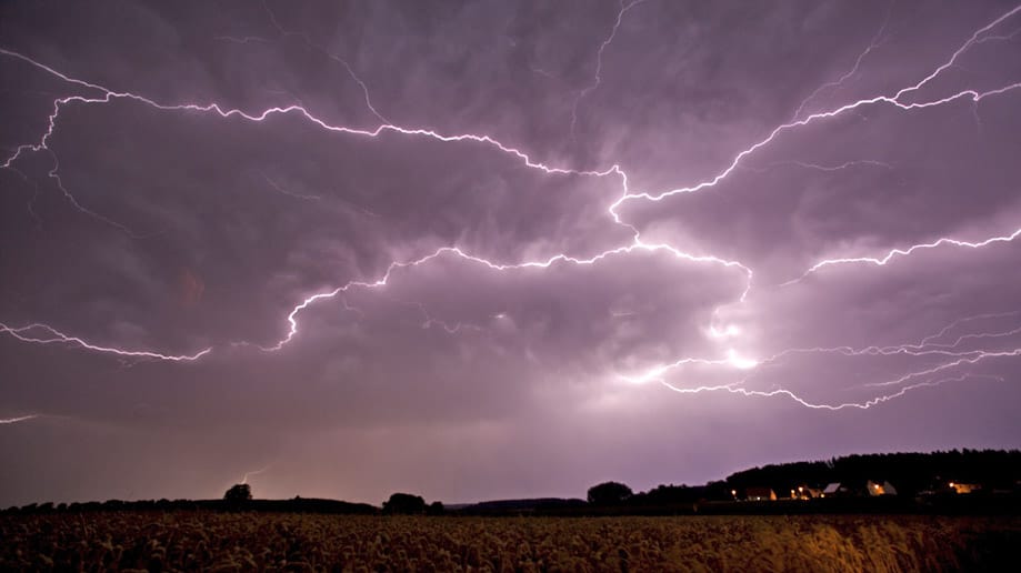 Blitze zucken über den nächtlichen Himmel.