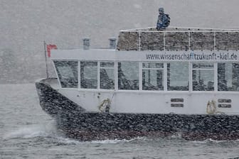 Eine Fähre fährt im Schneetreiben über die Förde in Kiel.