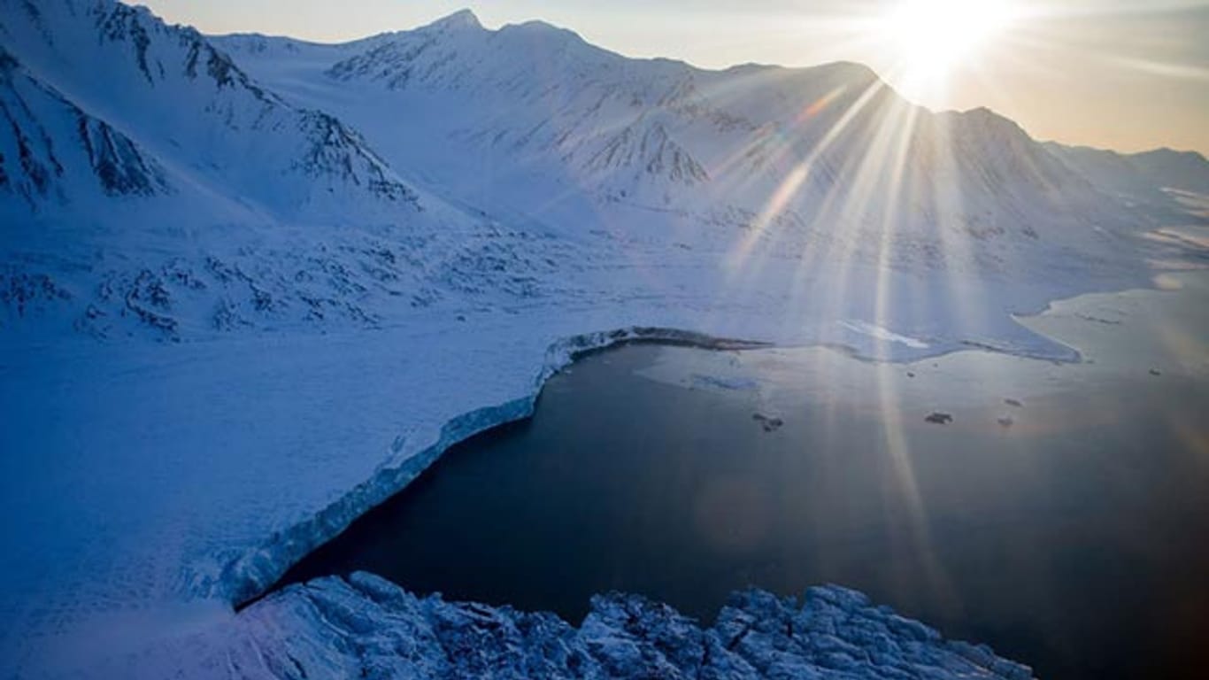 Auf Spitzbergen wird es warm. Die Sonne scheint über den bis zu 1000 Meter hohen Bergen im Nordre Isfjorden Nationalpark am Kongsfjord-Gletscher.