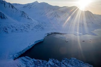 Auf Spitzbergen wird es warm. Die Sonne scheint über den bis zu 1000 Meter hohen Bergen im Nordre Isfjorden Nationalpark am Kongsfjord-Gletscher.