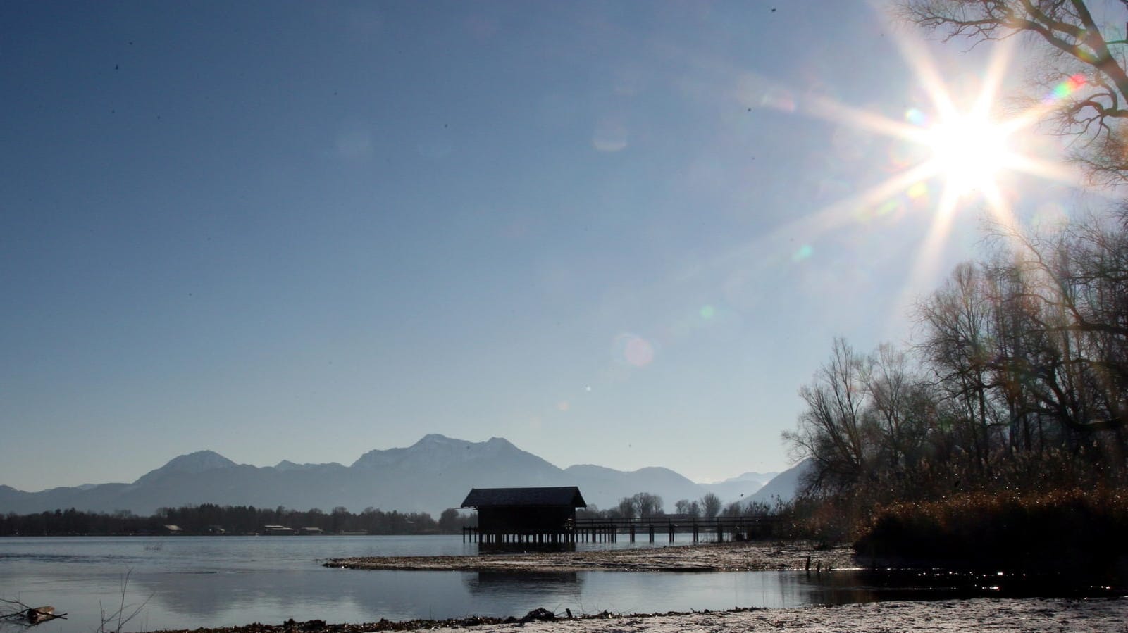 Das Ufer des Chiemsees im oberbayerischen Schöllkopf im Sonnenschein.