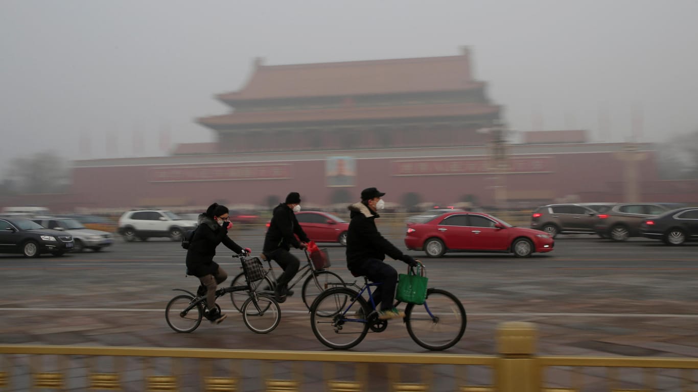 Radfahrer mit Schutzmasken am Tiananmen-Tor.
